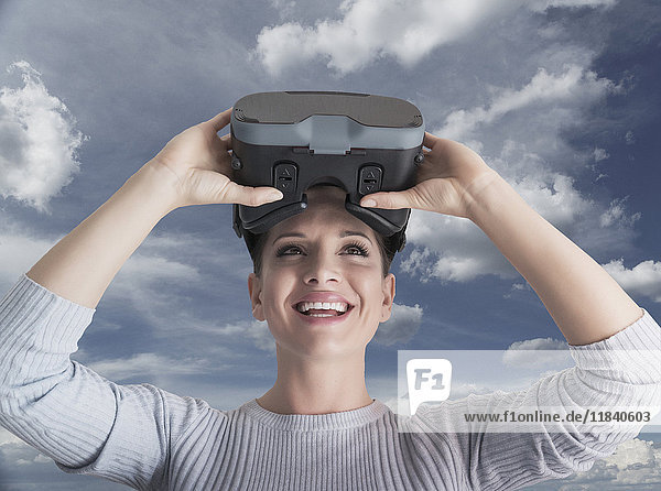 Caucasian woman removing virtual reality goggles