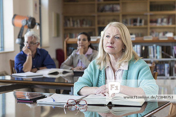 Curious older woman listening in library