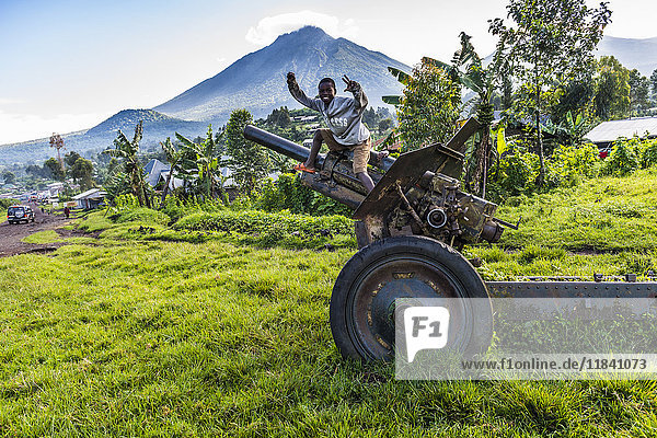 Boys posing on abandoned artillery in the Virunga National Park  Democratic Republic of the Congo  Africa