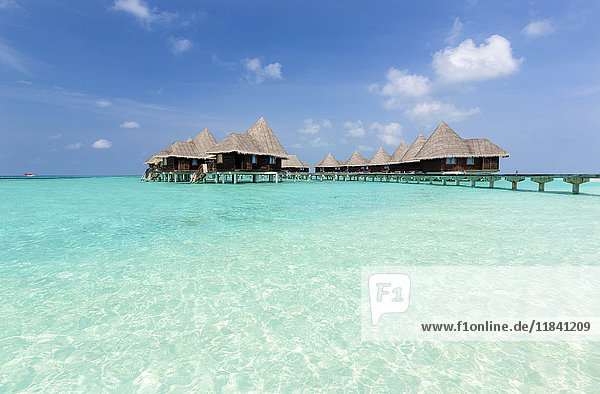 Klares Meer  blauer Himmel und Villen über dem Wasser  Coco Palm Resort  Dhuni Kolhu  Baa Atoll  Republik Malediven  Indischer Ozean  Asien