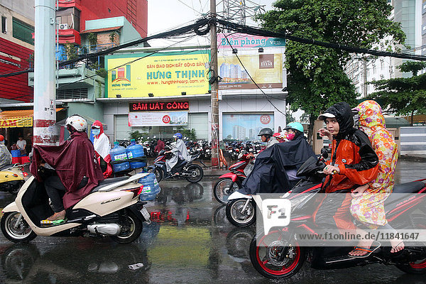 Motor scooters on Saigon Street in heavy monsoon rain  Ho Chi Minh City  Vietnam  Indochina  Southeast Asia  Asia