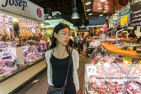 Eine junge Chinesin kauft auf dem Boqueria-Markt ein  einem der berühmtesten Märkte in ganz Spanien und dem berühmtesten in Barcelona; Barcelona  Katalonien  Spanien.