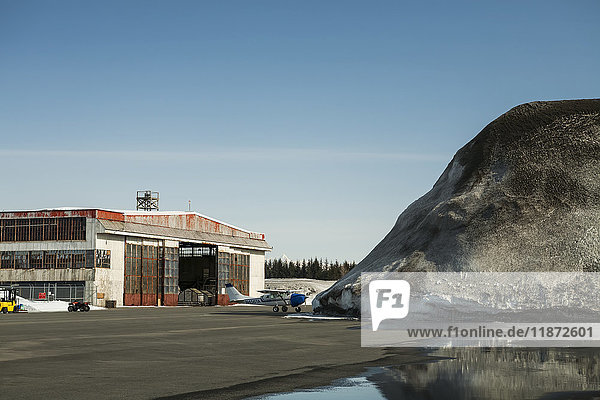 Blick auf einen Hangar und einen Schneehaufen auf dem Flughafen Yakutat  Südost-Alaska  USA