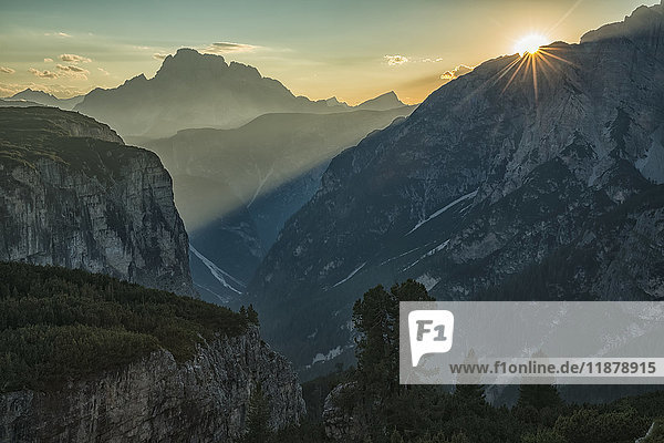 Die untergehende Sonne scheint durch die Dolomiten im Nationalpark der Drei Zinnen; Italien'.