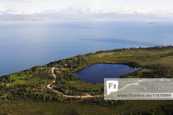 Ein See und eine kurvenreiche Straße an der Kachemak Bay mit Blick auf die Kenai Mountains  Kachemak Bay State Park; Homer  Alaska  Vereinigte Staaten von Amerika'.