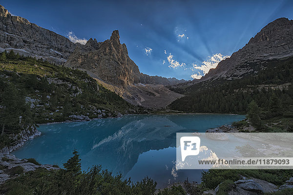 'Beams of sunlight shine through the late afternoon sky over Sorapiss Lake in the Italian Dolomites; Cortina Italy'