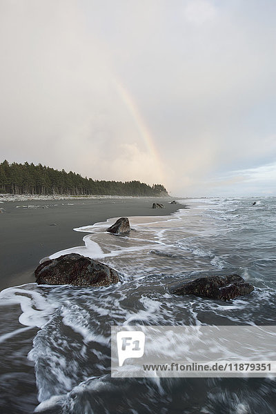 Wasser wird an den Sandstrand entlang der Küstenlinie mit Wald und Wolken gespült; Alaska  Vereinigte Staaten von Amerika'.