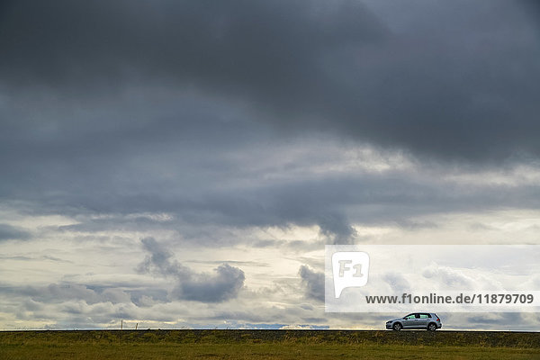 A lone car drives on the highway on the Snaefellsness Peninsula; Iceland