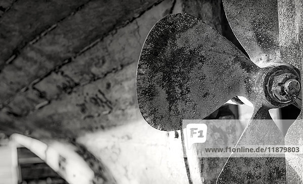 Close-up black and white image of the blades of a boat s rusted propeller; Seahouses  Northumberland  England