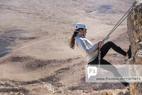 'A young woman rappelling into Ramon Crater  Ramon Nature Reserve; Mitzpe Ramon  South District  Israel'