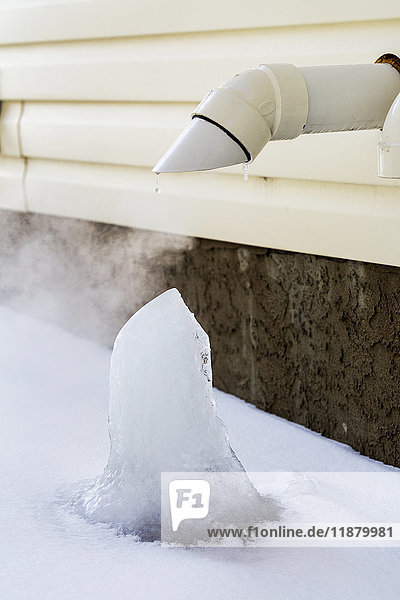 Nahaufnahme eines Ofenabzugsrohrs an der Außenseite eines Hauses mit Eisblockbildung; Calgary  Alberta  Kanada'.
