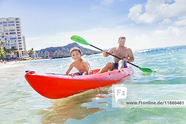 'A father and son spending time kayaking together off of Waikiki beach ; Honolulu  Oahu  Hawaii  United States of America'