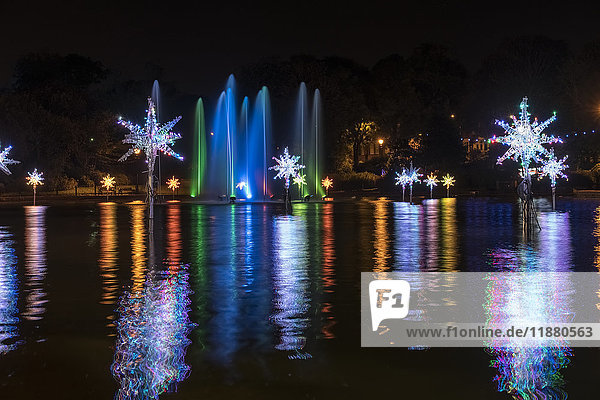 'Illuminated snowflakes and a spraying water fountain illuminated with colourful lights reflected in water; Sunderland  Tyne and Wear  England'