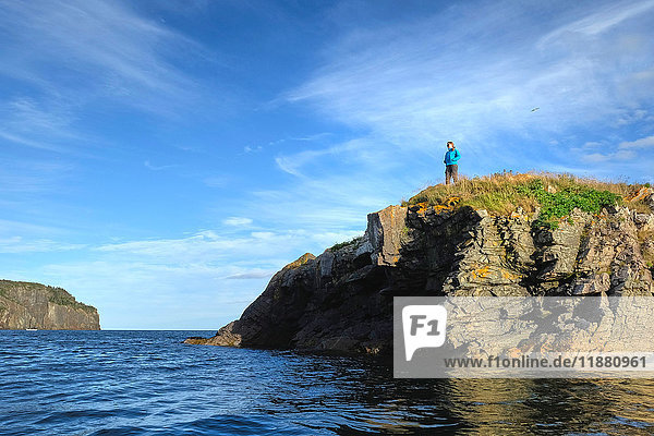 Mittelgroße erwachsene Frau  die von der Küstenklippe hinaussieht  St. John's  Neufundland  Kanada