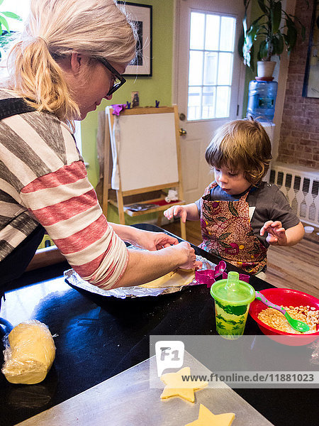 Woman and small son baking at kitchen counter