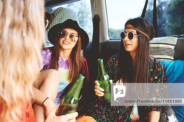 Three young boho women relaxing in recreational van