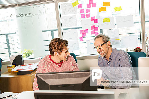 Männlicher Digital-Designer und Praktikant am Büroschreibtisch