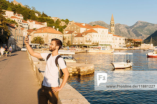 Man by harbor taking selfie  Perast  Montenegro  Europe