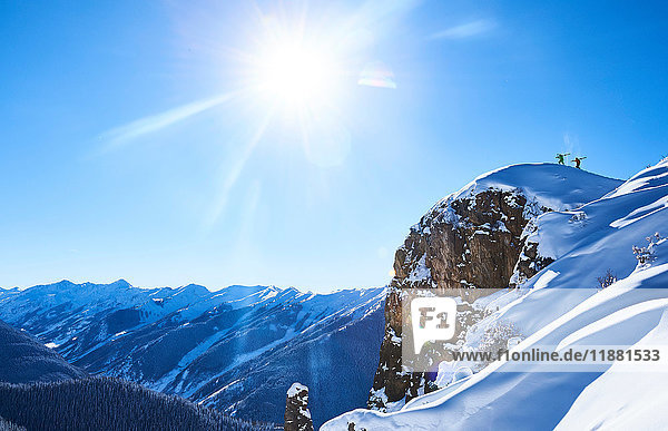 Fernsicht von zwei männlichen Skifahrern  die den schneebedeckten Bergrücken hinauf stapfen  Aspen  Colorado  USA