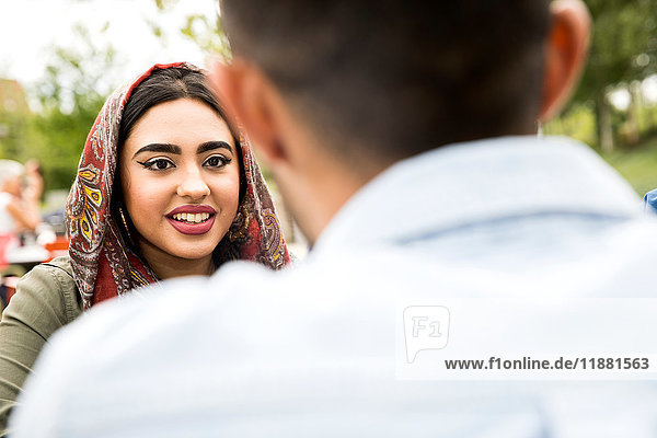 View over shoulder of woman looking at friend smiling