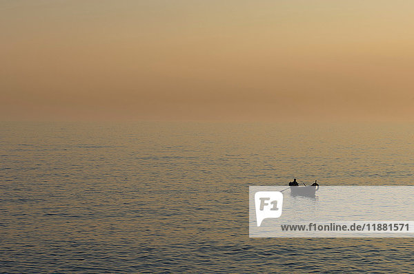 Fischer auf dem Wasser bei Sonnenuntergang  Camogli  Ligurien  Italien