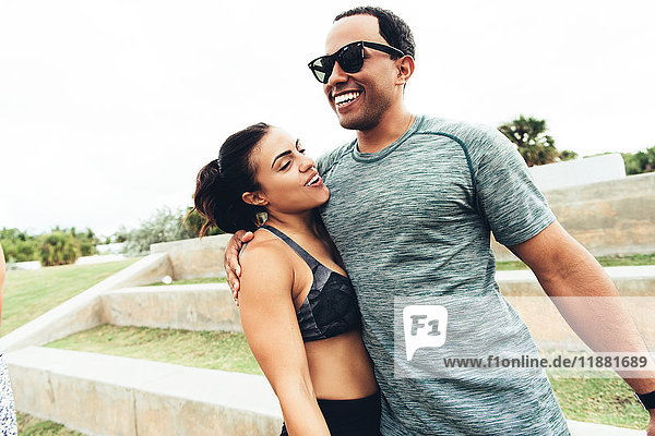 Junge Männer und Frauen in Sportkleidung im Freien Umarmungen South Point Park Miami Beach Florida USA