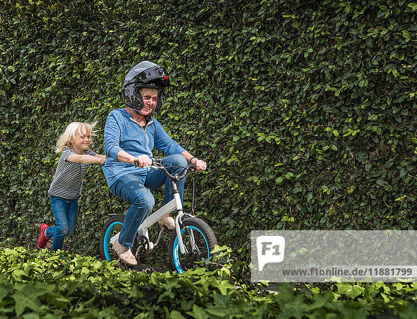 Grandson pushing grandmother on his bicycle