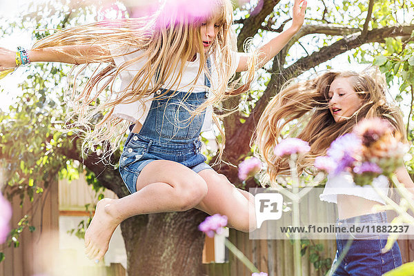 Mädchen im Garten springen in der Luft