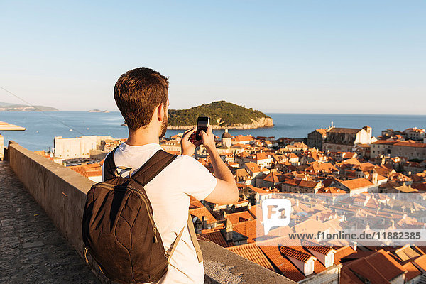 Man photographing sea over rooftops  Dubrovnik  Dubrovacko-Neretvanska  Croatia  Europe
