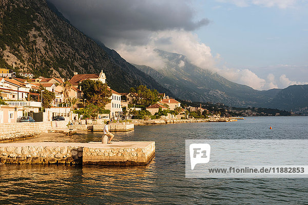 Junger Mann steht am Pier und schaut weg  Kotor  Montenegro  Europa