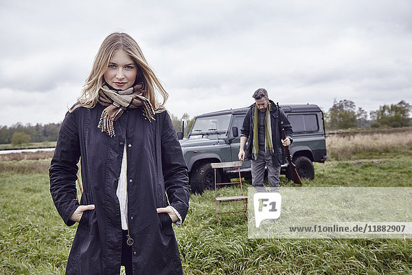 Hunting couple portrait of young woman in field