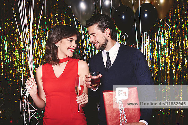 Mann und Frau auf der Party  Getränke haltend  lächelnd