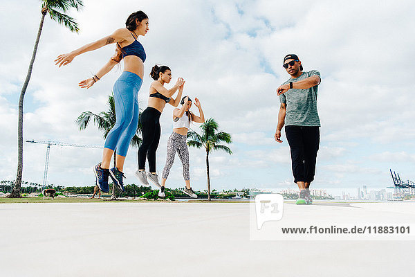 Drei Frauen trainieren mit einem persönlichen Trainer niedrige Blickwinkel South Point Park Miami Beach Florida USA