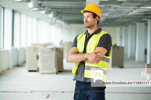 Arbeiter tragen Hi-Vis-Weste und stehen in neu errichteten Büroräumen