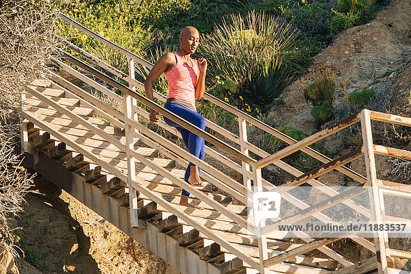 Junge Frau beim Sport  Laufen über Treppen in Strandnähe  niedriger Blickwinkel