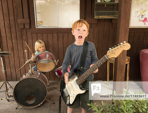 Children playing guitar and drums in band