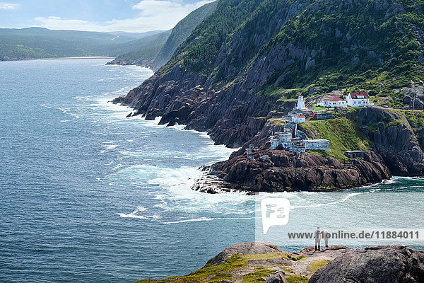 Couple looking out from coastal cliff  St John's  Newfoundland  Canada