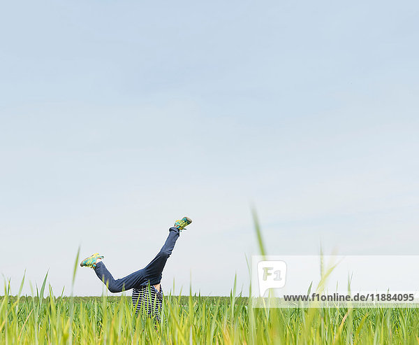 Boy cartwheeling in grass