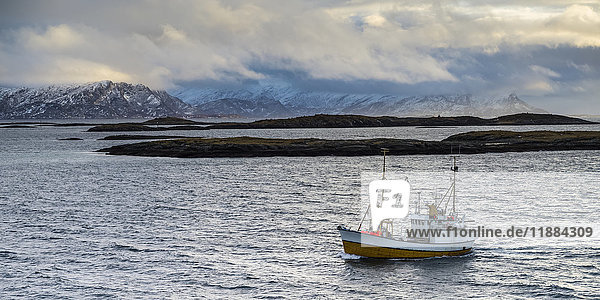 Ein kommerzielles Fischerboot auf dem Atlantik in der Arktis mit Blick auf die Berglandschaft; Norland  Norwegen'.