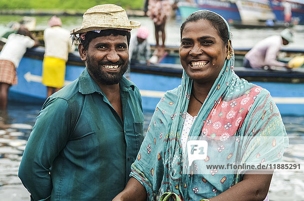 'Smiling man and woman in fishing village; Kadappuram  Kerala  India'