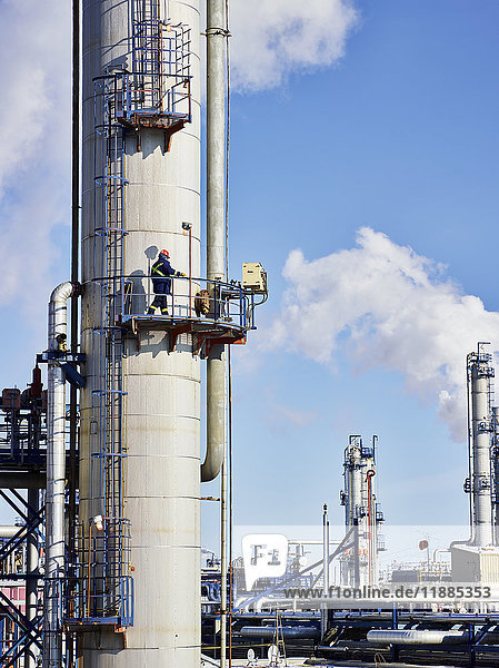 Ein Handwerker arbeitet auf einer Turmplattform in einer Raffinerie; Edmonton  Alberta  Kanada