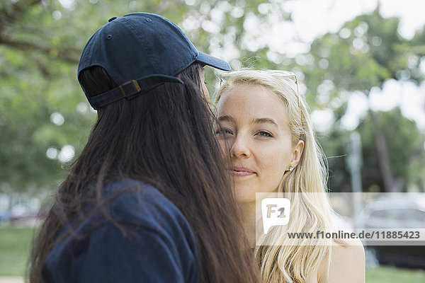 Portrait of blond woman with another woman at park