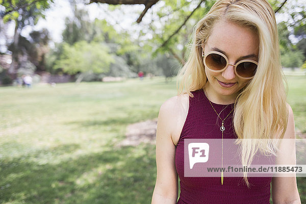 Young blond woman wearing sunglasses at park
