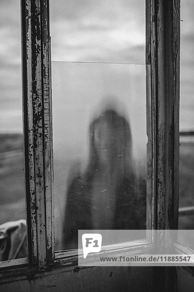Defokussiertes Bild des Mädchens durch das Fenster des alten Aussichtsturms gesehen