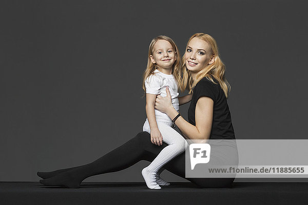 Seitenansicht Porträt von Mutter und Tochter auf grauem Hintergrund