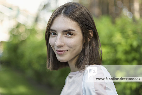 Close-up portrait of smiling young woman with short brown hair