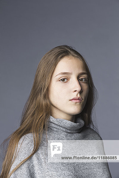 Portrait of teenage girl against gray background
