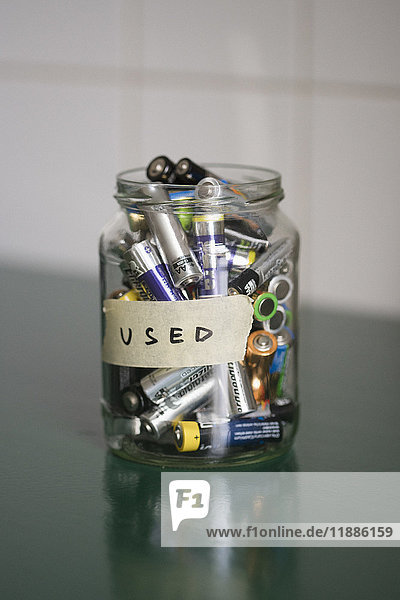 Nahaufnahme der Batterien im Glas mit USED-Etikett auf dem Tisch