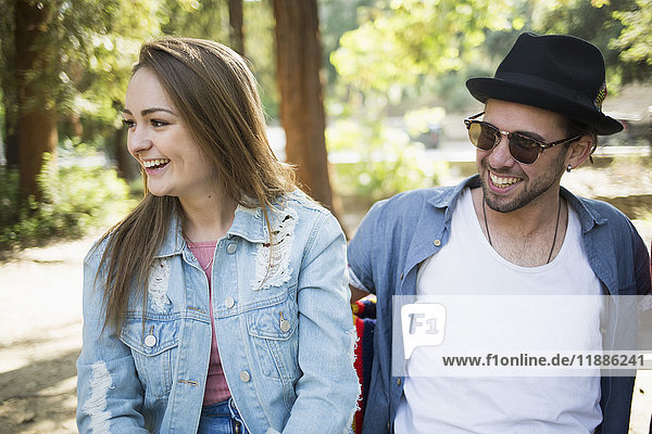 Happy couple sitting on bench in park