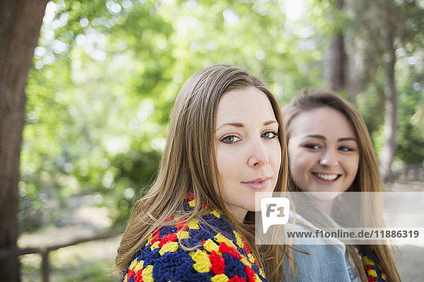 Portrait of beautiful woman sitting with female friend at park
